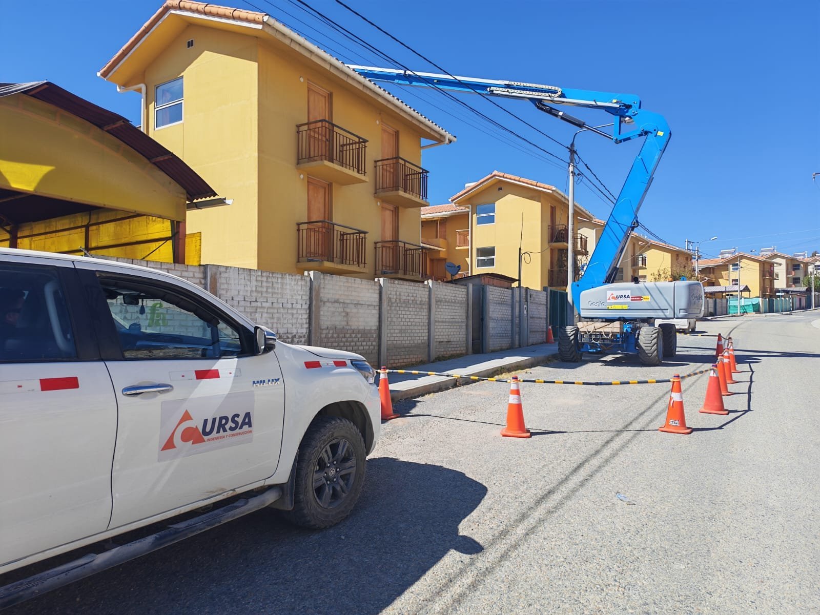 Camioneta y manlift de CURSA trabajando en una calle de viviendas de Nueva Fuerabamba